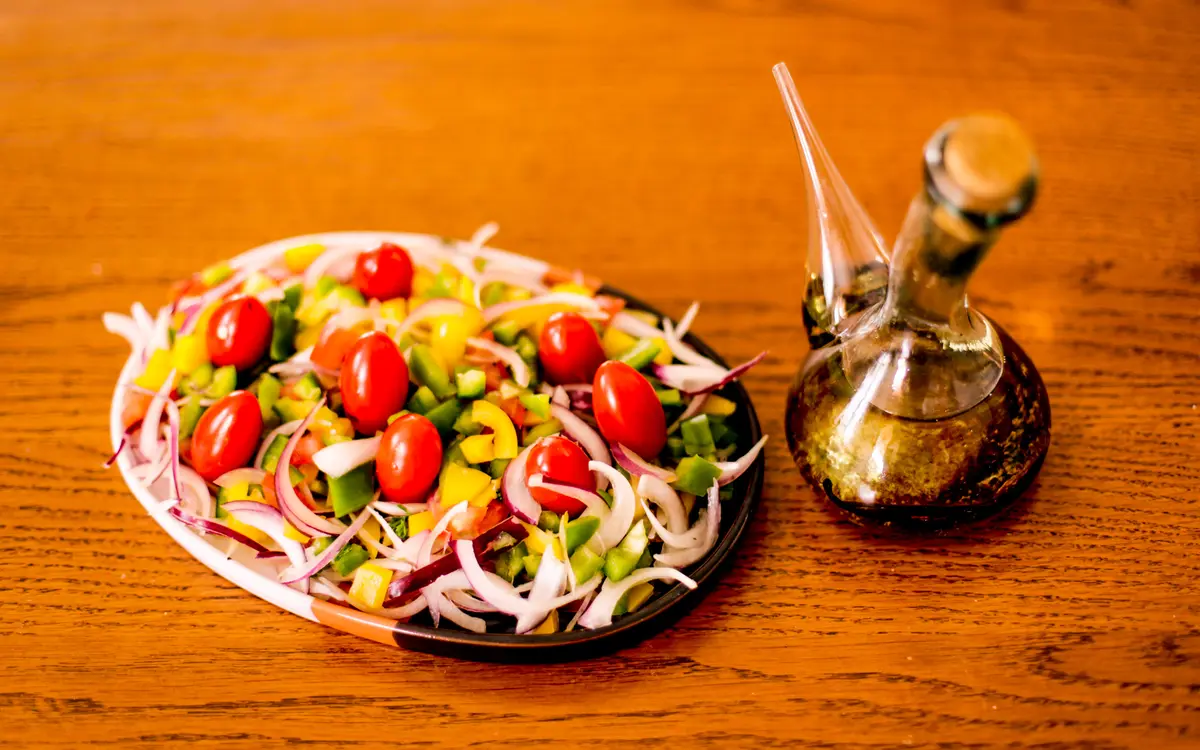 Salade de crudités aux tomates cerises, poivrons et oignons rouges, préparée par Au Lys de Réjane