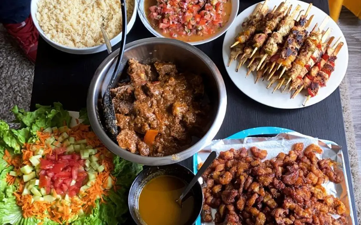 Table de buffet dressée par Au Lys de Réjane : mafé, brochettes, poulet grillé, salades de crudités et semoule