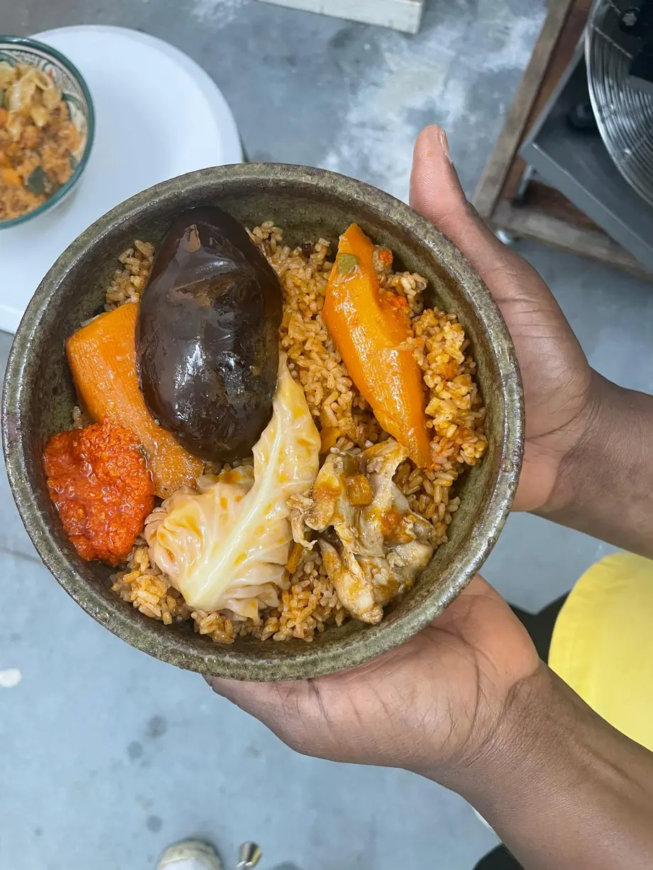 Bol de riz aux épices garni de poulet, aubergine, carotte et chou, servi avec une sauce pimentée
